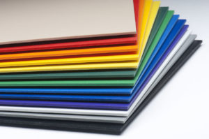 A stack of expanded foam PVC plastic sheets arranged in a rainbow pattern