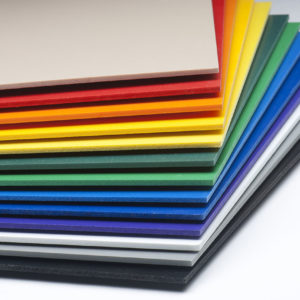 A stack of expanded foam PVC plastic sheets arranged in a rainbow pattern