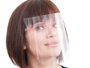 Woman wearing a clear plastic face shield in the workplace