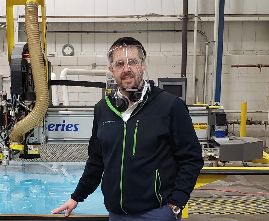 man wearing plastic face shield by manufacturer Polymershapes which helps protect from Coronavirus also known as covid-19