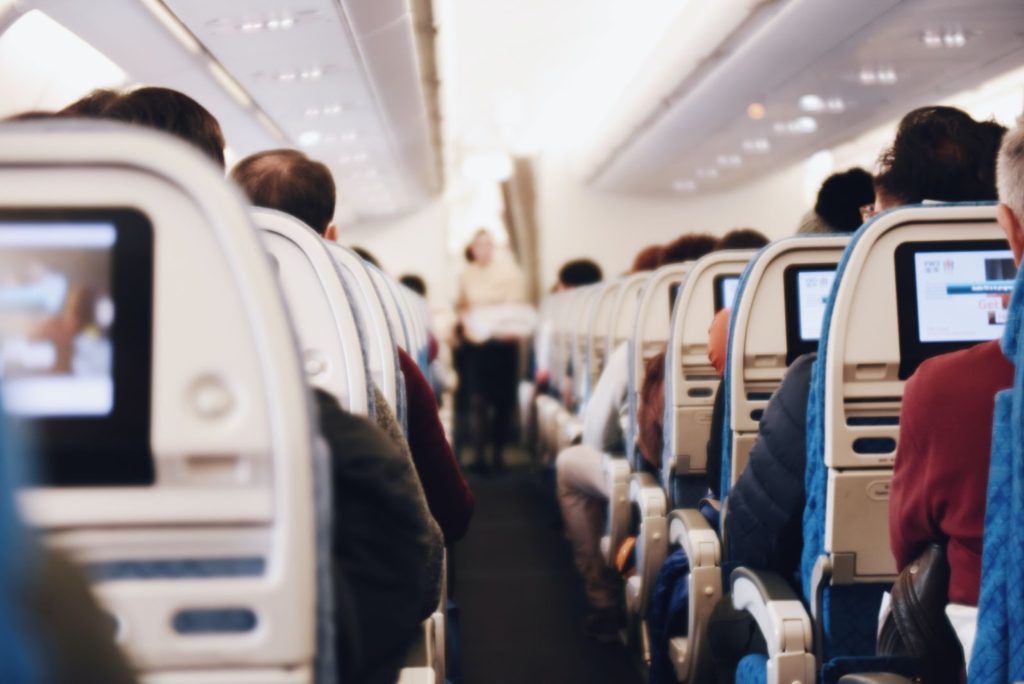 airplane aisle with passengers in their seats